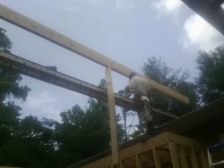 Carpenter setting a ridge beam over a new addition frame — Ice Dam Removal by Roofing Brothers in Walnut Creek