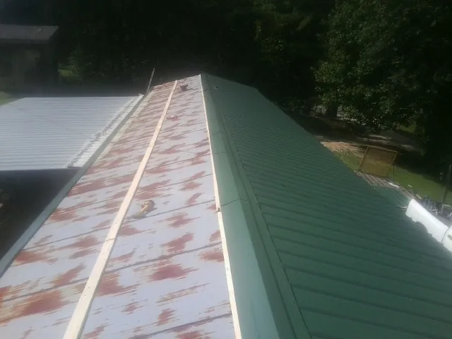 Old rusted panels beside newly installed green metal roofing — Wind Damage Roof Repair by Roofing Brothers in Walnut Creek